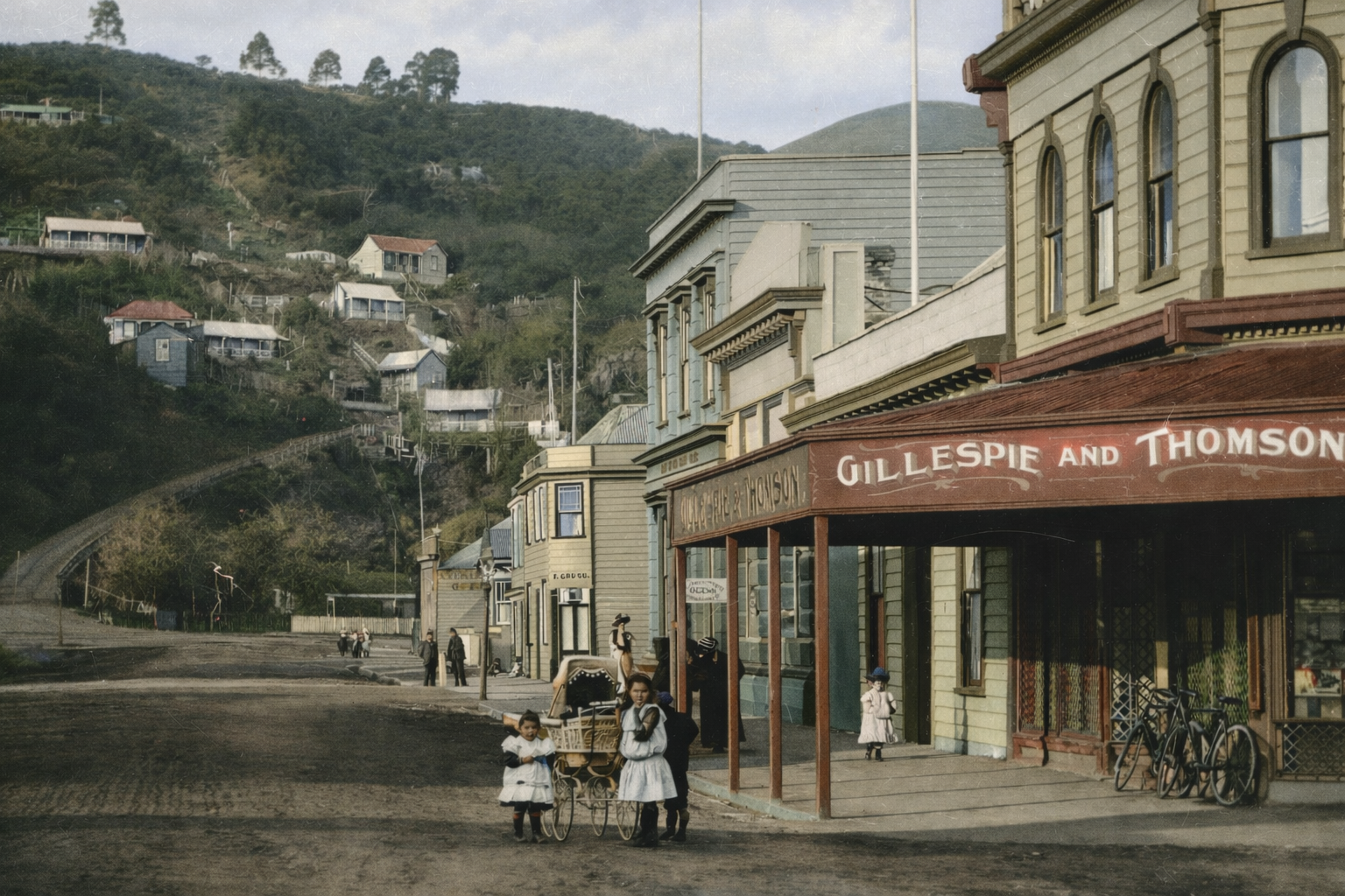 Vintage street scene with pedestrians and a store named 'Gillespie and Thomson' on a hilly background.